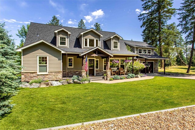 255 Windsor Ct, Bigfork, MT 59911 - rear view of property featuring a porch, stone siding, and a yard