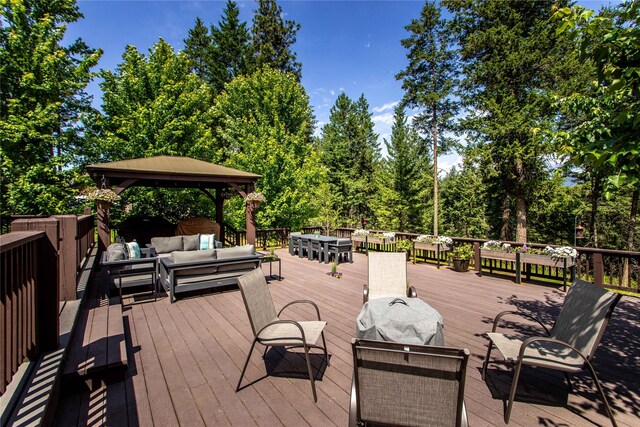 255 Windsor Ct, Bigfork, MT 59911 - wooden terrace featuring an outdoor hangout area, a gazebo, and view of wooded area