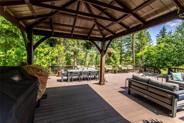 255 Windsor Ct, Bigfork, MT 59911 - deck featuring outdoor dining space, an outdoor hangout area, a gazebo, and view of scattered trees