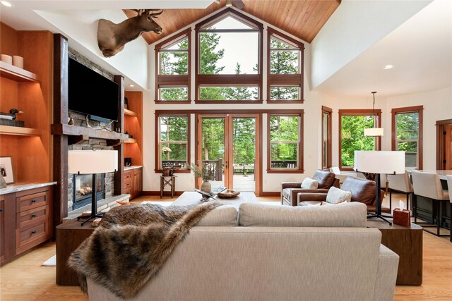 255 Windsor Ct, Bigfork, MT 59911 - living room featuring a fireplace, light wood-style floors, and high vaulted ceiling