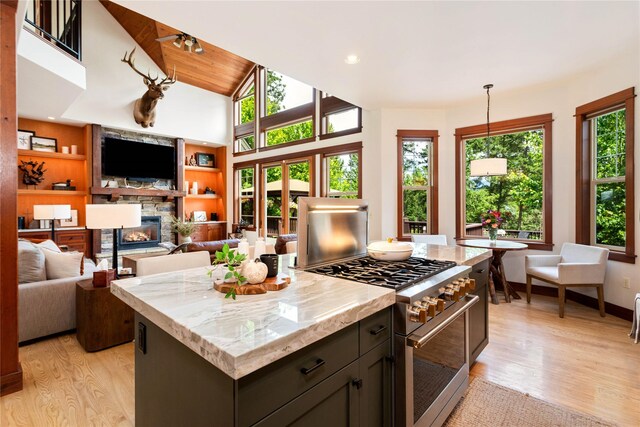 255 Windsor Ct, Bigfork, MT 59911 - kitchen featuring high end stove, a fireplace, light wood finished floors, a kitchen island, and recessed lighting