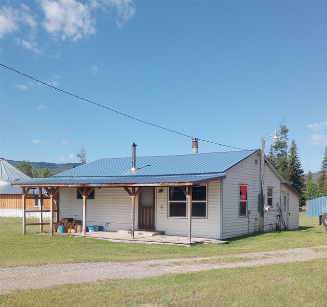 4117 Sherlock Ln, Lincoln, MT 59639 - view of front facade with a front yard, a metal roof, and a chimney