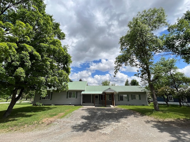 214 Church St, Thompson Falls, MT 59873 - ranch-style house with dirt driveway, a front yard, and a metal roof