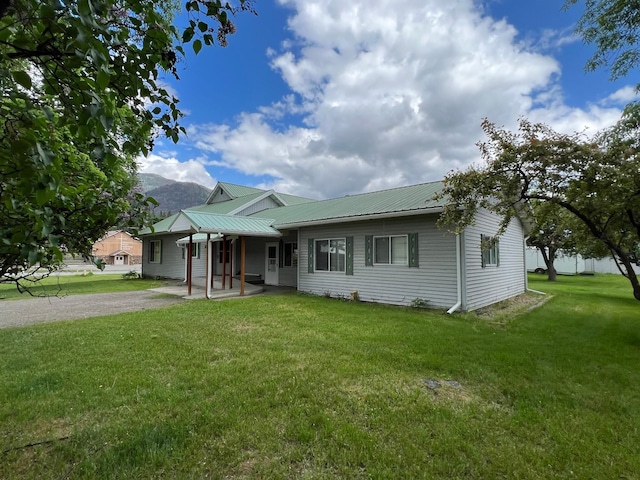 214 Church St, Thompson Falls, MT 59873 - single story home with a metal roof, a front yard, a patio area, and a mountain view