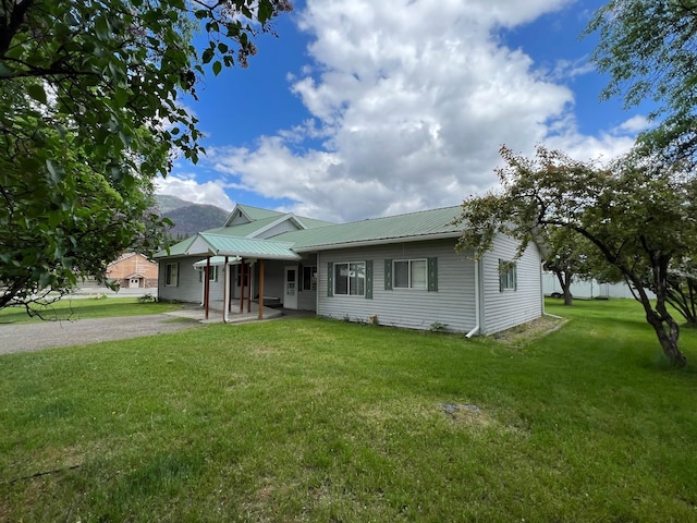 214 Church St, Thompson Falls, MT 59873 - ranch-style home featuring a front yard, a metal roof, a mountain view, and a patio area