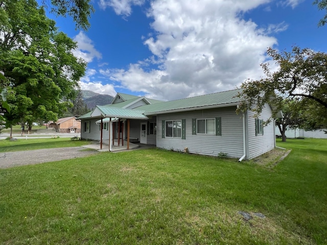 214 Church St, Thompson Falls, MT 59873 - view of front of house with a front lawn, a metal roof, and a mountain view