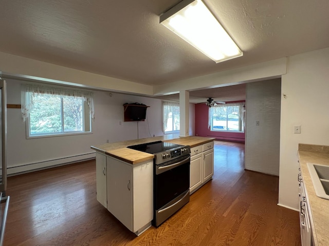 214 Church St, Thompson Falls, MT 59873 - kitchen with stainless steel range with electric stovetop, a baseboard radiator, wood finished floors, white cabinets, and wood counters