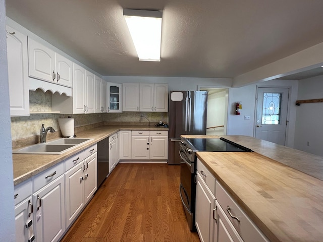 214 Church St, Thompson Falls, MT 59873 - kitchen featuring appliances with stainless steel finishes, butcher block countertops, white cabinets, glass insert cabinets, and dark wood-style flooring