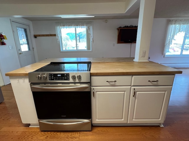 214 Church St, Thompson Falls, MT 59873 - kitchen with stainless steel electric range oven, butcher block countertops, white cabinetry, and light wood-style flooring