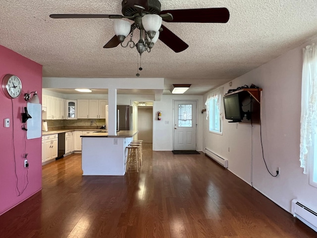 214 Church St, Thompson Falls, MT 59873 - kitchen with a baseboard heating unit, a textured ceiling, ceiling fan, a breakfast bar, and white cabinetry