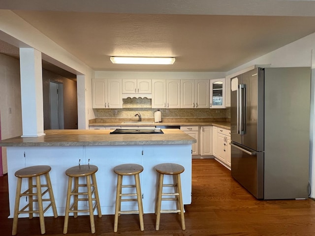 214 Church St, Thompson Falls, MT 59873 - kitchen with freestanding refrigerator, white cabinetry, a kitchen bar, glass insert cabinets, and dark wood finished floors
