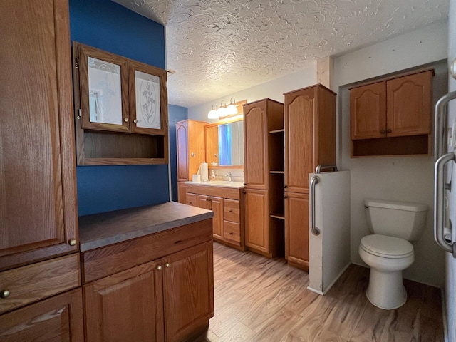 214 Church St, Thompson Falls, MT 59873 - bathroom featuring wood finished floors, vanity, and a textured ceiling