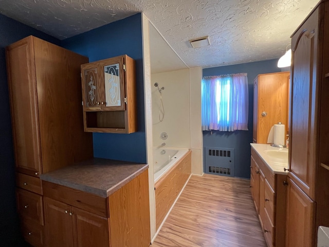 214 Church St, Thompson Falls, MT 59873 - full bathroom with radiator, wood finished floors, vanity, and a textured ceiling