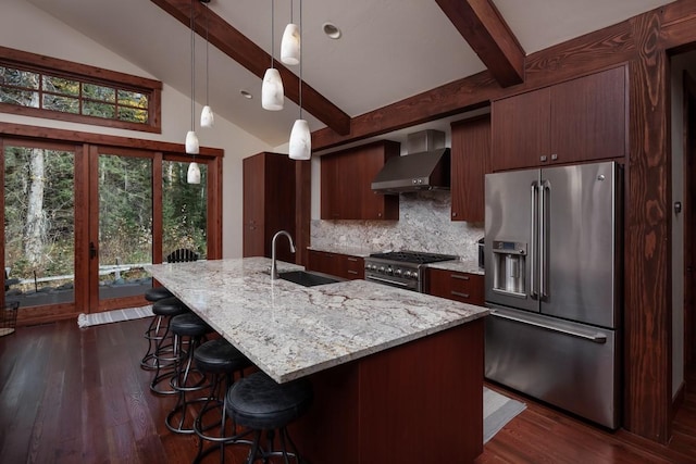 628 Nature Trl, Whitefish, MT 59937 - kitchen with high end appliances, wall chimney range hood, backsplash, dark wood finished floors, and a breakfast bar area