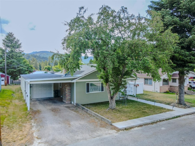 1508 Lolo Ave, Libby, MT 59923 - view of front of house featuring a front yard, asphalt driveway, a mountain view, and a garage