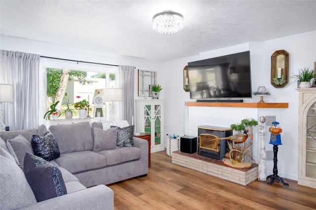 1508 Lolo Ave, Libby, MT 59923 - living room with a fireplace, a textured ceiling, wood finished floors, and a chandelier