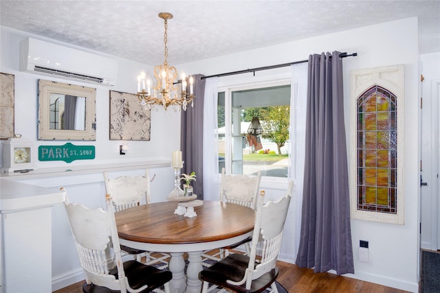1508 Lolo Ave, Libby, MT 59923 - dining space with a wall unit AC, a chandelier, a textured ceiling, and wood finished floors