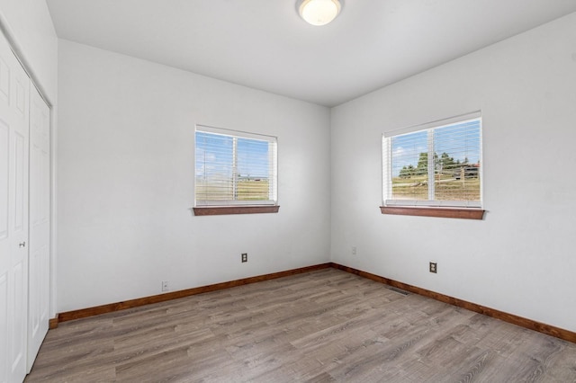 75 N Hill Rd, Kalispell, MT 59901 - unfurnished bedroom featuring multiple windows, wood finished floors, and a closet