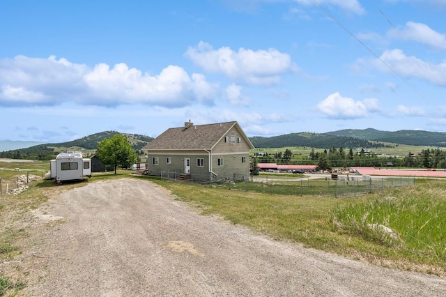 75 N Hill Rd, Kalispell, MT 59901 - view of property exterior featuring a mountain view, a storage shed, a view of countryside, a chimney, and driveway