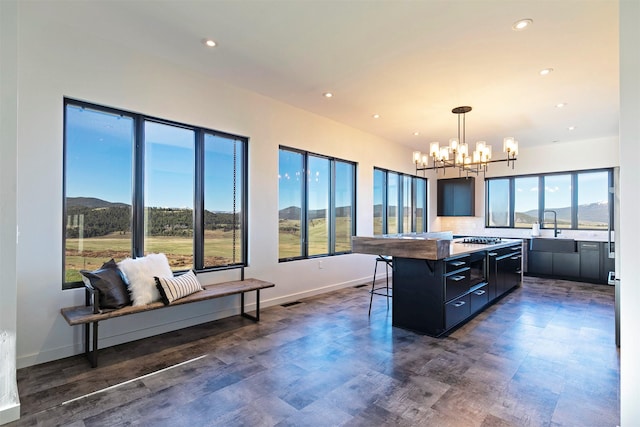 4722 Skalkaho Rd, Philipsburg, MT 59858 - kitchen featuring a kitchen breakfast bar, a chandelier, a center island, dark cabinets, and recessed lighting