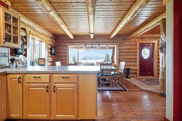 182 Moondance Trl, Bigfork, MT 59911 - kitchen with a wood ceiling with exposed beams, a peninsula, glass insert cabinets, log walls, and hardwood / wood-style flooring
