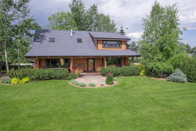 182 Moondance Trl, Bigfork, MT 59911 - log home featuring covered porch, log siding, a front yard, and roof with shingles