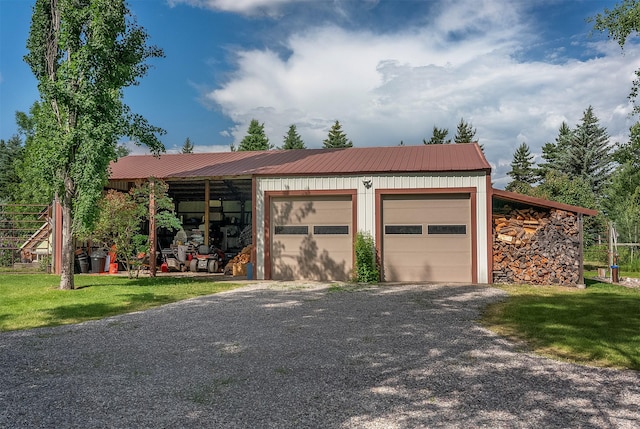 182 Moondance Trl, Bigfork, MT 59911 - ranch-style house featuring an outbuilding, a metal roof, board and batten siding, a detached garage, and gravel driveway