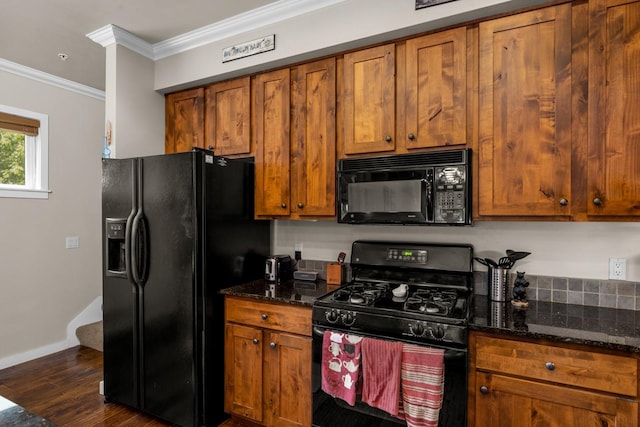 6203 Monterra Ave Unit H, Whitefish, MT 59937 - kitchen featuring black appliances, brown cabinets, dark wood finished floors, dark stone countertops, and ornamental molding
