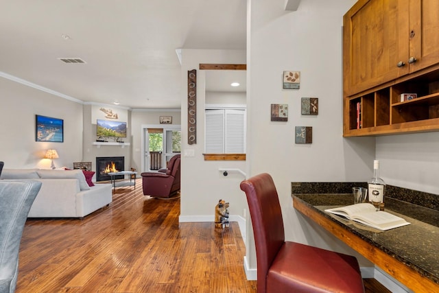 6203 Monterra Ave Unit H, Whitefish, MT 59937 - dining space featuring dark wood-style floors, a glass covered fireplace, crown molding, and recessed lighting