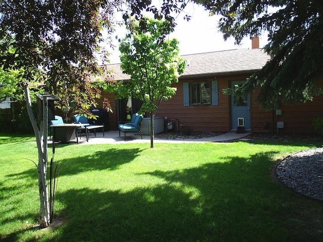 2424 Teakwood Ln, Helena, MT 59601 - back of house featuring a lawn, a patio area, and a chimney