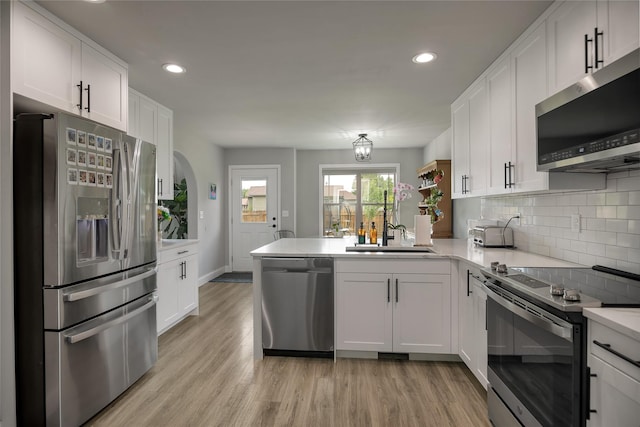 3806 Timothy Ln, Helena, MT 59602 - kitchen with stainless steel appliances, a peninsula, light countertops, white cabinetry, and decorative backsplash