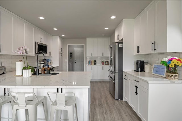 3806 Timothy Ln, Helena, MT 59602 - kitchen featuring stainless steel appliances, backsplash, a peninsula, recessed lighting, and white cabinets