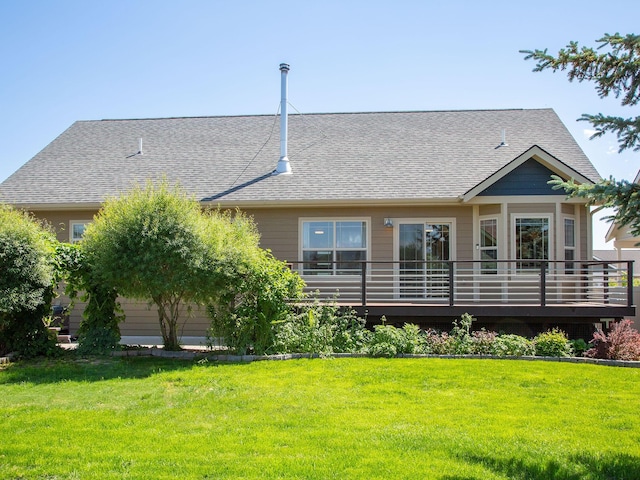 521 Evening Star Ln, Columbia Falls, MT 59912 - back of property with roof with shingles, a lawn, and a deck