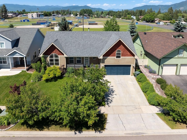 521 Evening Star Ln, Columbia Falls, MT 59912 - view of front facade featuring a mountain view, concrete driveway, an attached garage, and roof with shingles