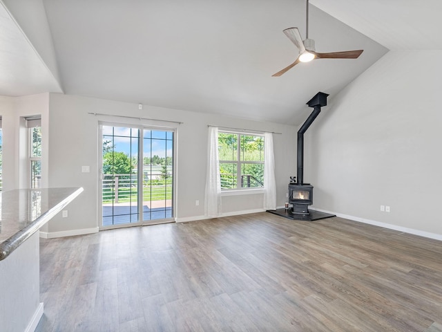 521 Evening Star Ln, Columbia Falls, MT 59912 - unfurnished living room with a wood stove, a ceiling fan, light wood-style flooring, and high vaulted ceiling