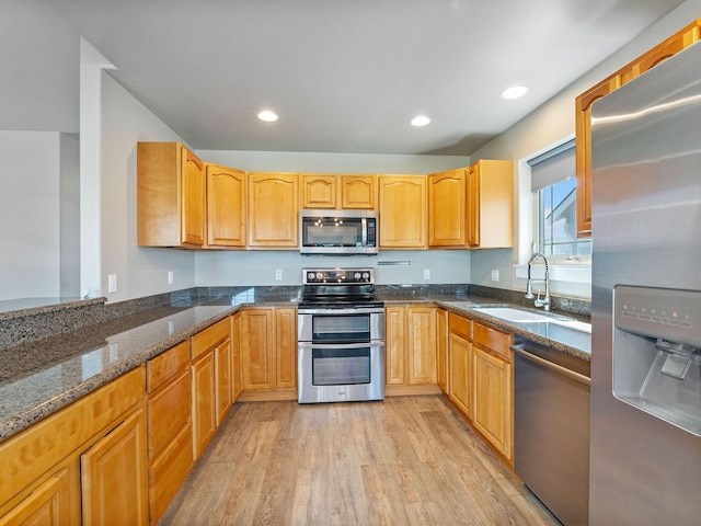 521 Evening Star Ln, Columbia Falls, MT 59912 - kitchen with stainless steel appliances, dark stone counters, light wood finished floors, and recessed lighting