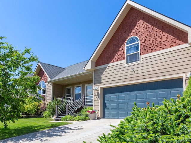 521 Evening Star Ln, Columbia Falls, MT 59912 - townhome / multi-family property with concrete driveway, a front yard, roof with shingles, and an attached garage