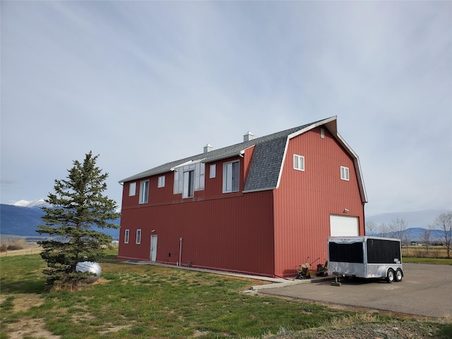 650 Hollibaugh Rd, Stevensville, MT 59870 - view of side of property with a detached garage, a barn, an outdoor structure, a chimney, and a shingled roof