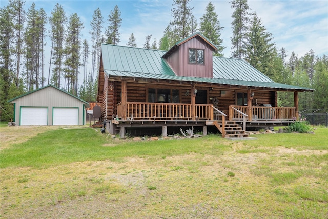 6343 Packer Creek Rd, Haugan, MT 59842 - cabin with log siding, a garage, a front lawn, a standing seam roof, and an outbuilding