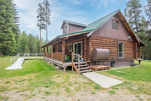 6343 Packer Creek Rd, Haugan, MT 59842 - rear view of house with heating fuel, a yard, log siding, a wooden deck, and a metal roof