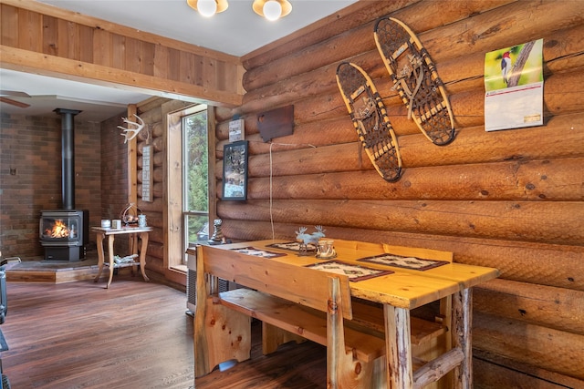 6343 Packer Creek Rd, Haugan, MT 59842 - dining space featuring rustic walls, a wood stove, and wood finished floors