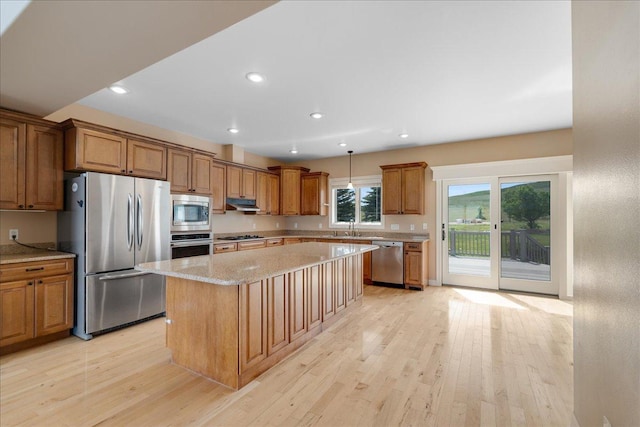40 Butch Cassidy Loop, Great Falls, MT 59405 - kitchen with appliances with stainless steel finishes, a center island, brown cabinetry, light wood-style floors, and recessed lighting