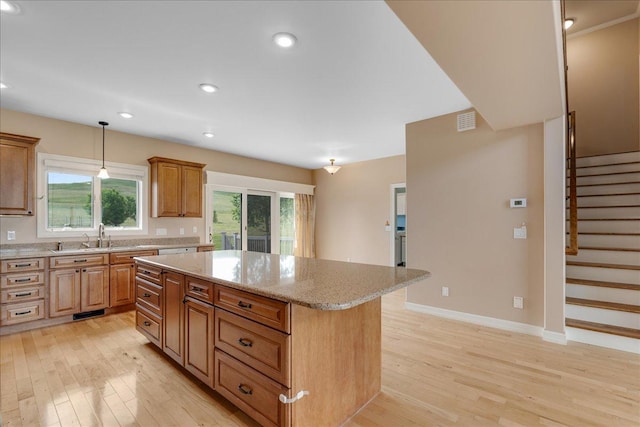 40 Butch Cassidy Loop, Great Falls, MT 59405 - kitchen with a center island, light wood-type flooring, light stone countertops, pendant lighting, and recessed lighting