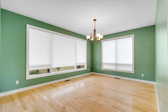 40 Butch Cassidy Loop, Great Falls, MT 59405 - spare room featuring a chandelier, wood finished floors, and plenty of natural light