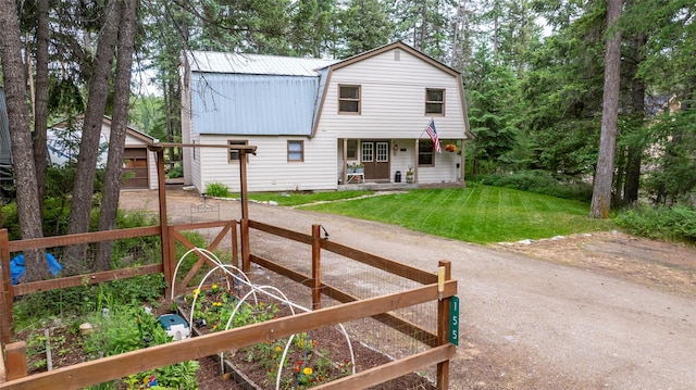 155 Lake Peter Ct, Kalispell, MT 59901 - view of front of property with a metal roof, a gambrel roof, a front yard, a garden, and a porch