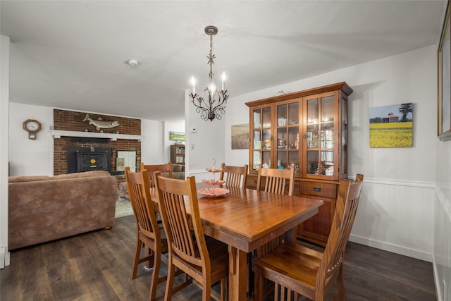 155 Lake Peter Ct, Kalispell, MT 59901 - dining area with dark wood-type flooring, a chandelier, a brick fireplace, and a wainscoted wall
