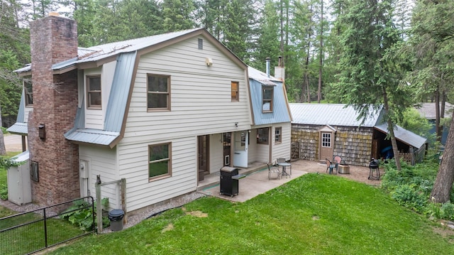 155 Lake Peter Ct, Kalispell, MT 59901 - back of property featuring a chimney, a metal roof, and a patio