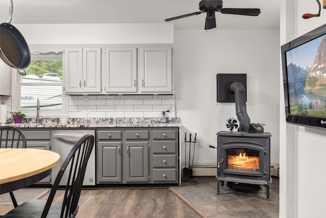 155 Lake Peter Ct, Kalispell, MT 59901 - kitchen with gray cabinets, a wood stove, dishwasher, a ceiling fan, and decorative backsplash
