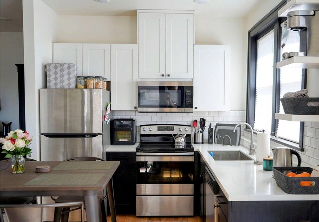 101 W Quartz St Unit 1A, Butte, MT 59701 - kitchen with stainless steel appliances, light countertops, white cabinets, and decorative backsplash