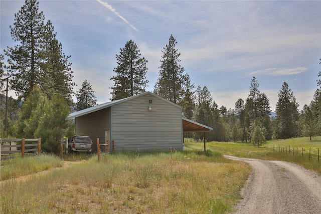 86 Steamboat Way W, Thompson Falls, MT 59873 - view of side of home with driveway, a carport, and an outbuilding